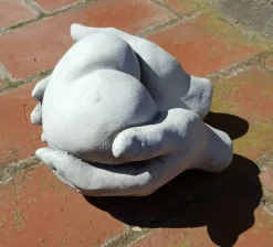 Hænder holder/giver hjerte i hvid beton