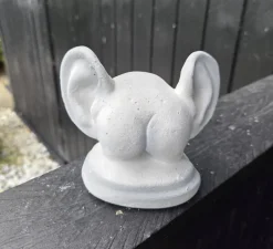Lille røv med ører i hvid cement